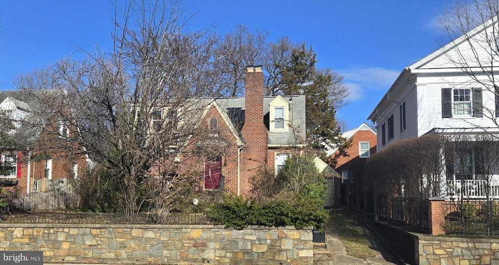 view of side of property with brick siding and a chimney