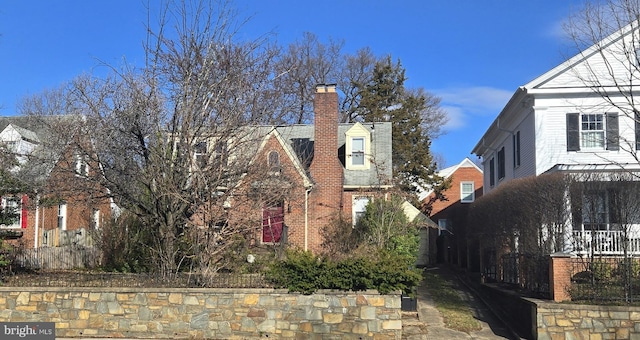 view of side of property with brick siding and a chimney