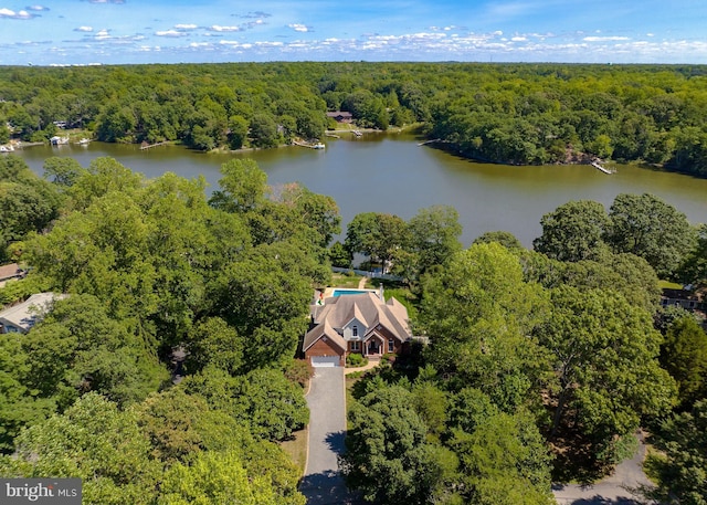 birds eye view of property featuring a wooded view and a water view