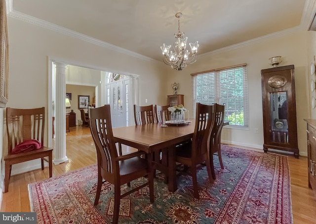 dining room with light wood finished floors, baseboards, a chandelier, decorative columns, and ornamental molding