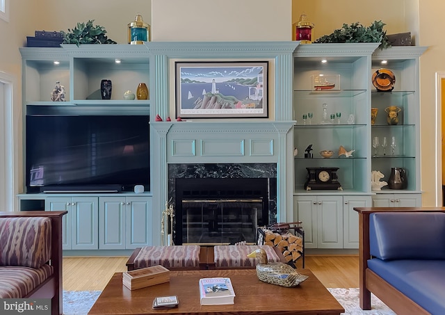 living area with light wood-type flooring and a high end fireplace