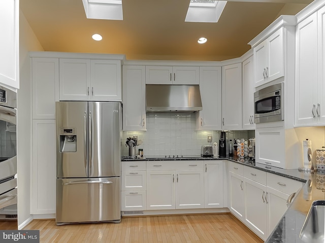 kitchen featuring white cabinetry, under cabinet range hood, backsplash, and appliances with stainless steel finishes