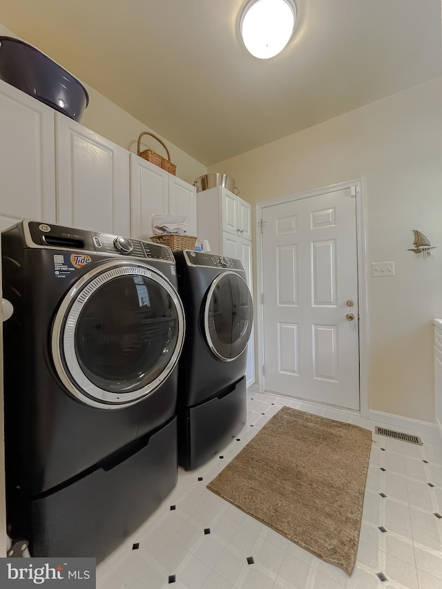 laundry area with cabinet space, baseboards, and washer and clothes dryer