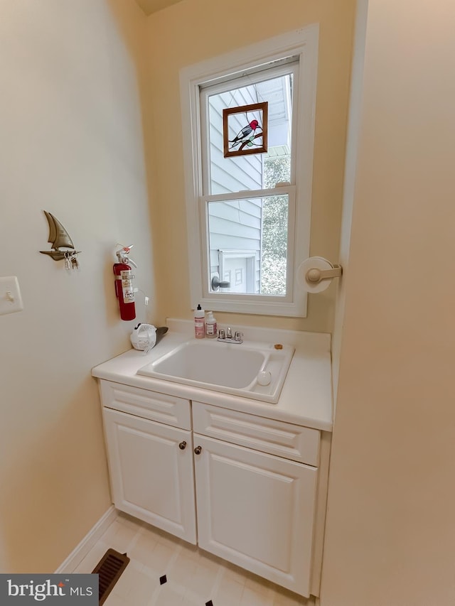 bathroom featuring visible vents, baseboards, and a sink