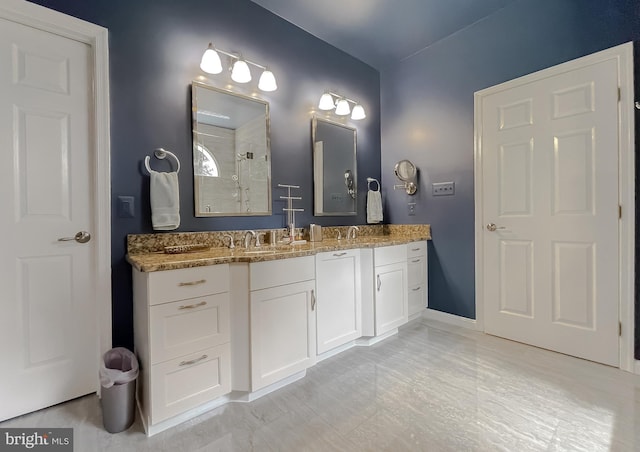 full bathroom with a tile shower, double vanity, and a sink