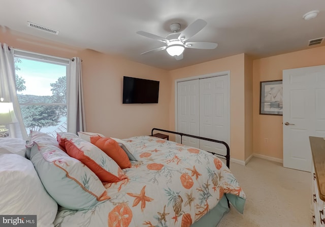 bedroom with a closet, visible vents, light carpet, and a ceiling fan