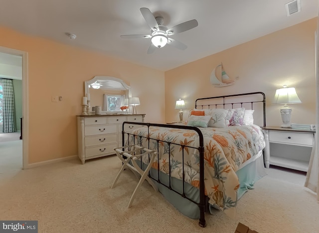 bedroom with visible vents, baseboards, light colored carpet, and ceiling fan