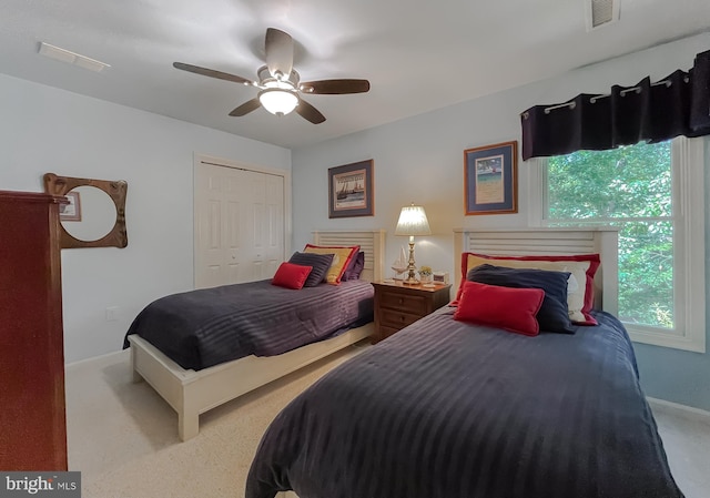 carpeted bedroom featuring baseboards, visible vents, a closet, and ceiling fan