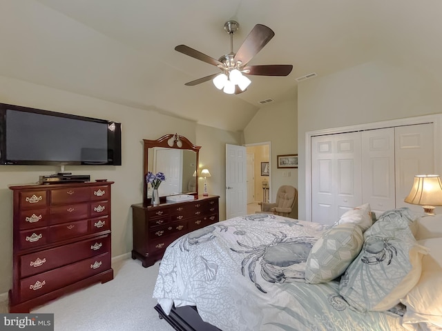 bedroom featuring visible vents, lofted ceiling, light colored carpet, and a closet