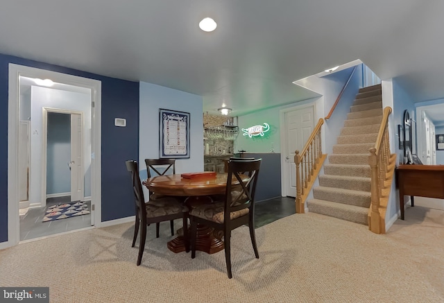 dining space featuring baseboards, carpet floors, and stairs