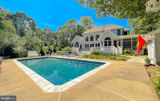 pool with a patio and a sunroom