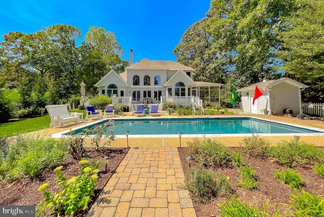 pool featuring a patio, an outdoor structure, and fence