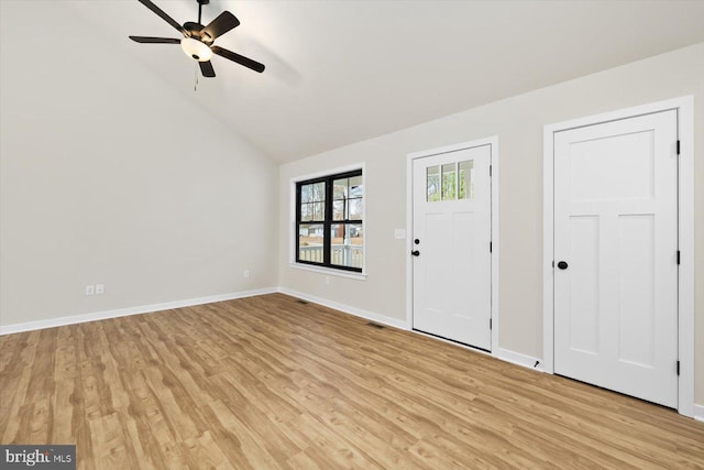 foyer entrance featuring light wood-style floors, baseboards, vaulted ceiling, and a ceiling fan