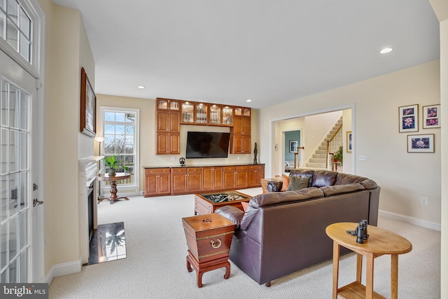 carpeted living room with stairway, recessed lighting, a fireplace, and baseboards