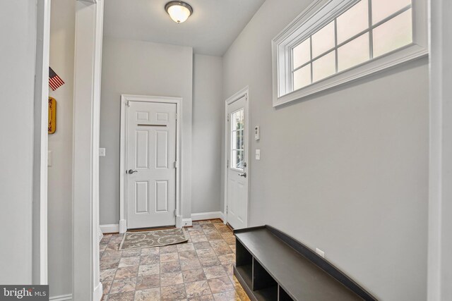 entrance foyer with baseboards and stone finish flooring