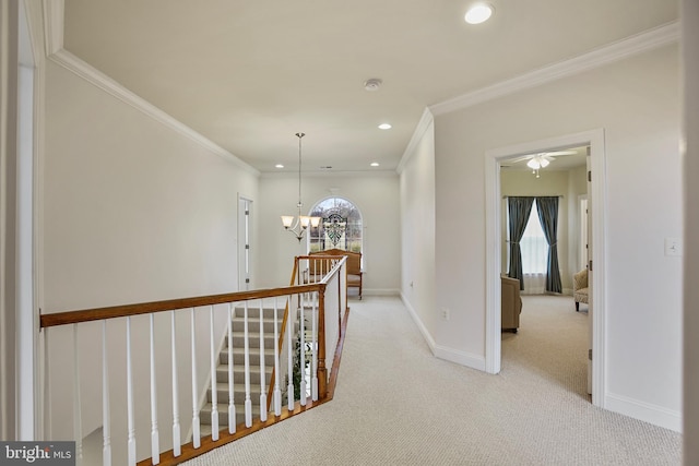 hall with baseboards, an upstairs landing, carpet floors, and a chandelier