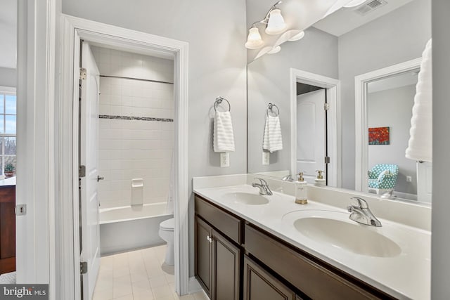 full bath featuring a sink, visible vents, toilet, and double vanity