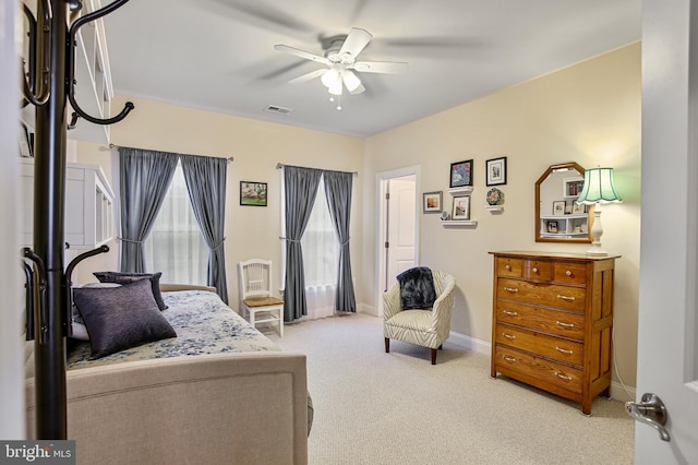 bedroom with a ceiling fan, baseboards, visible vents, and light carpet