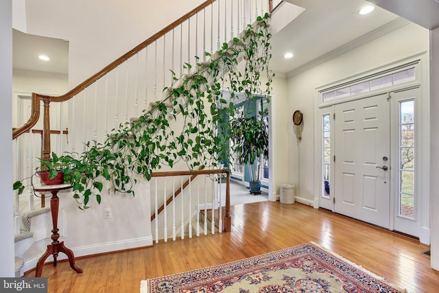 entryway featuring stairway, baseboards, recessed lighting, ornamental molding, and hardwood / wood-style flooring