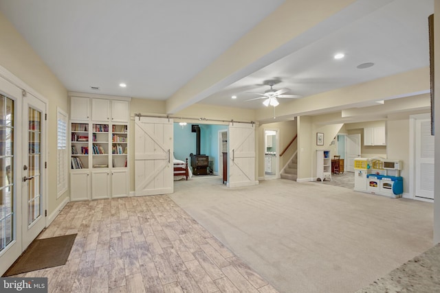 interior space with stairs, a barn door, recessed lighting, and light wood-style floors