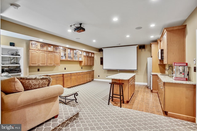 kitchen with a center island, glass insert cabinets, recessed lighting, stainless steel appliances, and a sink