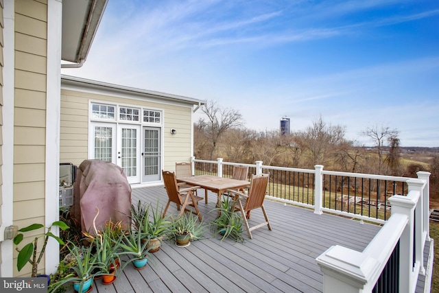 wooden deck featuring outdoor dining area and french doors