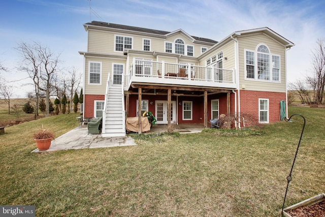 rear view of house with a yard, a patio, brick siding, and a deck