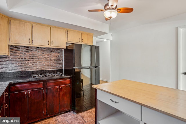 kitchen featuring decorative backsplash, gas cooktop, a ceiling fan, and freestanding refrigerator