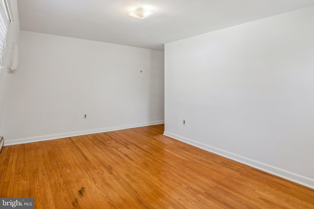 unfurnished room with baseboards and light wood-style flooring