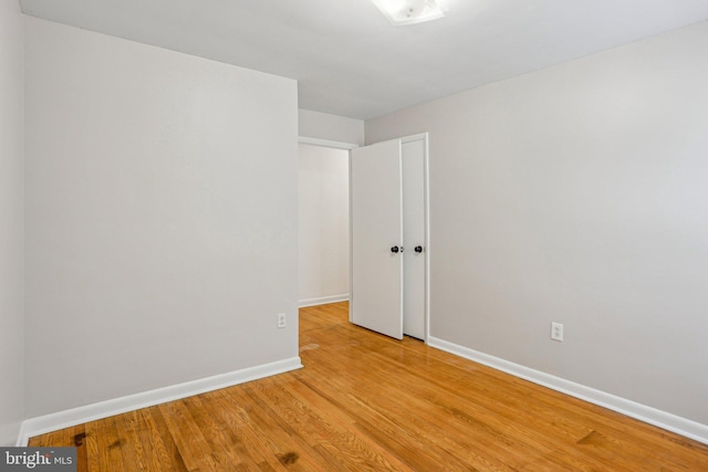 unfurnished room with light wood finished floors and baseboards