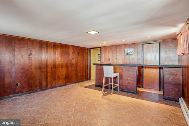 kitchen with recessed lighting, brown cabinetry, wood walls, and a baseboard radiator