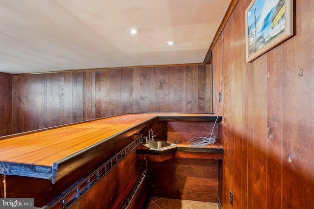 bar featuring tile patterned floors, recessed lighting, indoor wet bar, and a sink