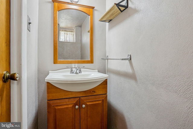 bathroom featuring vanity and a textured wall