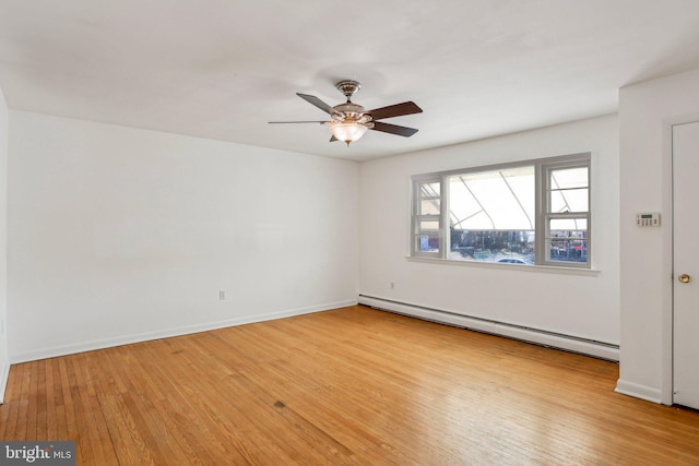 spare room featuring baseboards, baseboard heating, ceiling fan, and hardwood / wood-style flooring