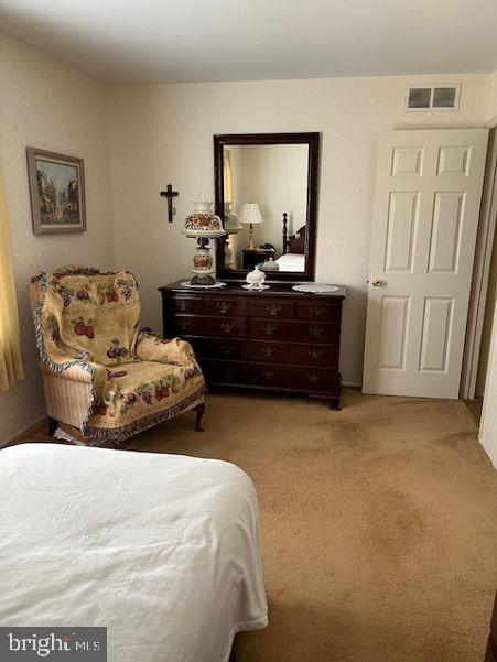 bedroom featuring visible vents and light carpet