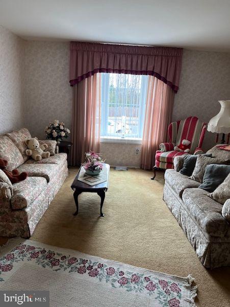 living area featuring wallpapered walls and carpet