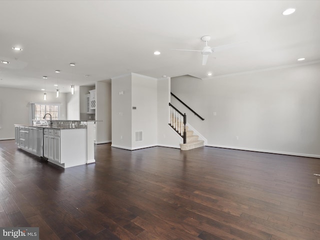 unfurnished living room with dark wood-style floors, recessed lighting, visible vents, and stairs