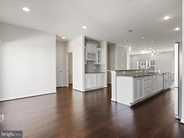 kitchen with freestanding refrigerator, dark wood-style flooring, decorative backsplash, and recessed lighting