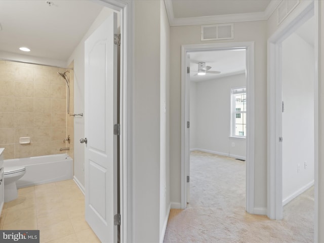 hall with baseboards, visible vents, ornamental molding, and light colored carpet