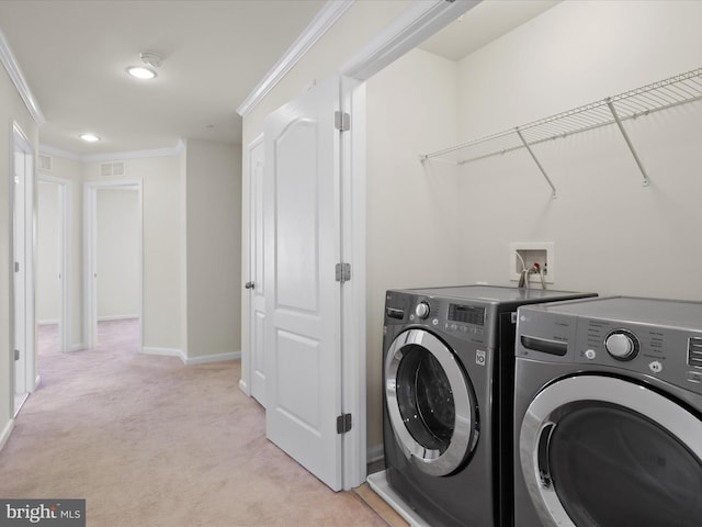 laundry room featuring laundry area, baseboards, light colored carpet, ornamental molding, and washer and dryer