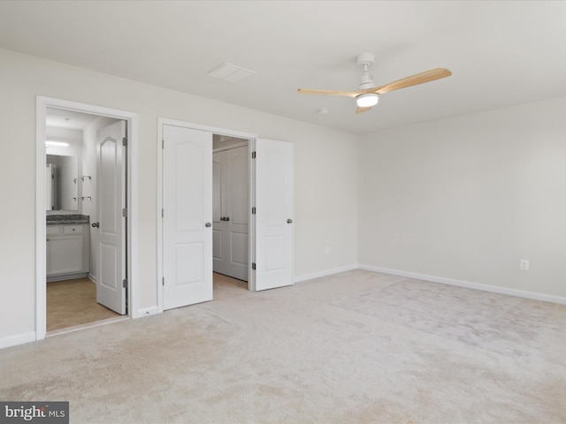 unfurnished bedroom featuring baseboards, a walk in closet, and light colored carpet