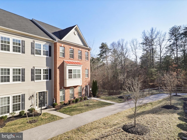 view of front of property featuring brick siding and fence