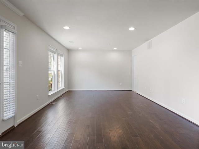 empty room with baseboards, dark wood finished floors, visible vents, and recessed lighting