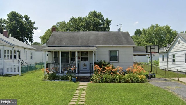 bungalow-style house with a porch, a front yard, and fence