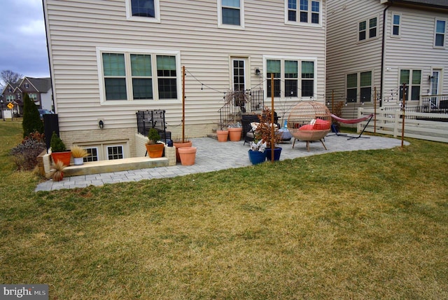 back of house featuring a patio, a lawn, and fence