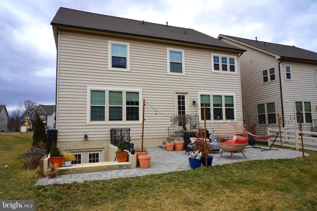 rear view of property featuring a patio area and a lawn