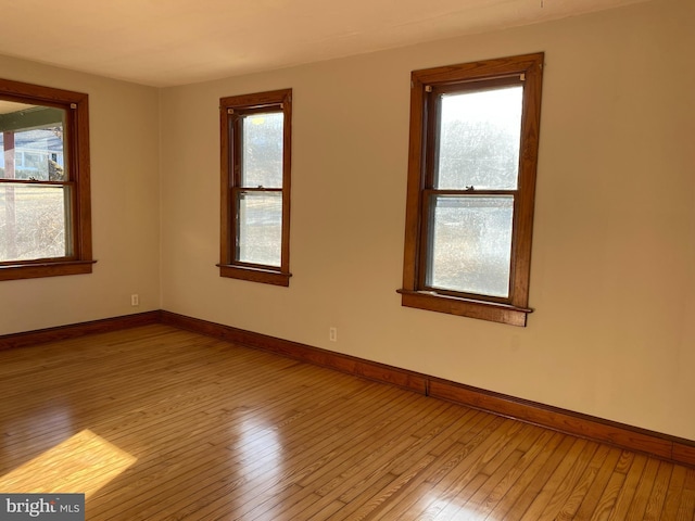 empty room featuring wood-type flooring and baseboards