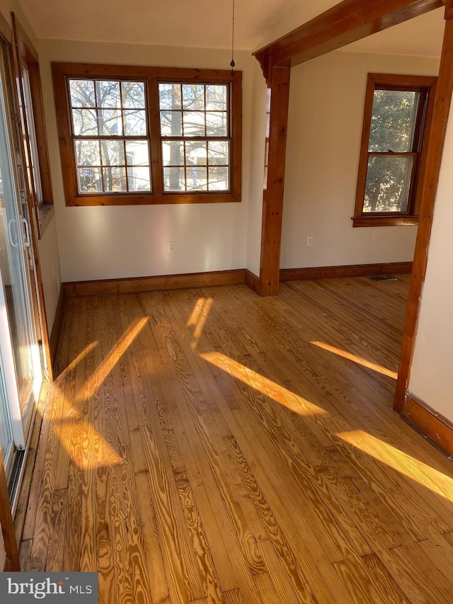 empty room with hardwood / wood-style flooring and baseboards