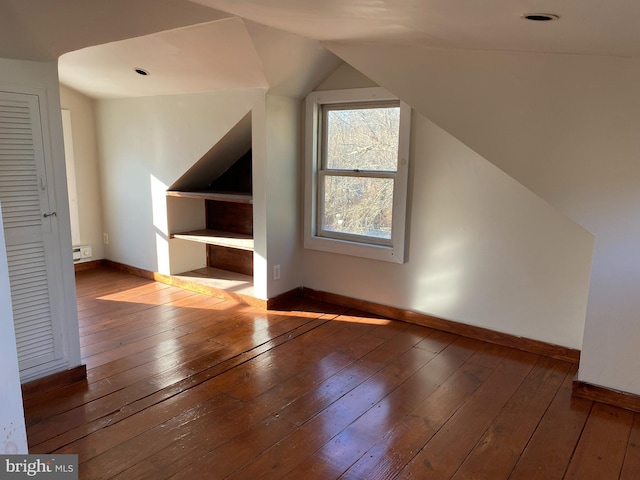 additional living space featuring lofted ceiling, baseboards, and hardwood / wood-style flooring