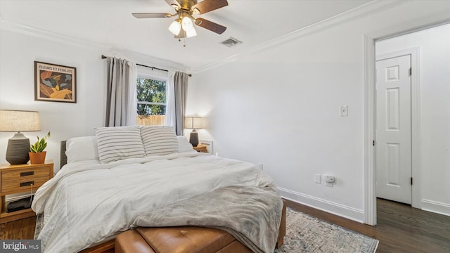 bedroom featuring baseboards, visible vents, crown molding, and wood finished floors